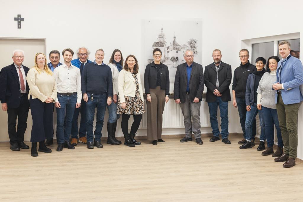 Landrat Dr. Oliver Bär (rechts) und die Berger Bürgermeisterin Patricia Rubner (Mitte) gemeinsam mit den Gästen und LAG-Mitgliedern bei der Besichtigung des sanierten Mehrzweckgebäudes der Gemeinde Berg.